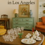 Elegant estate sale setup featuring vintage china and glassware on a wooden table, styled by Triumphant Estate Sales in Los Angeles.